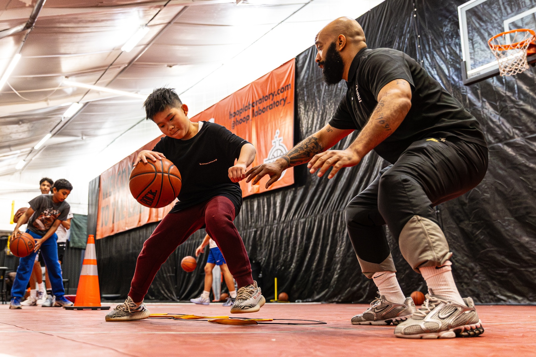 Coach training a young player on ball handling in a Hoop Lab session
